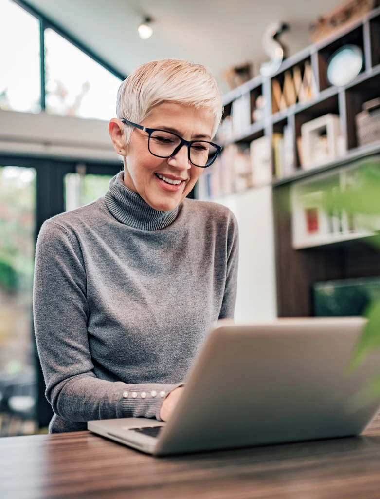 Executive smiling while working on a laptop